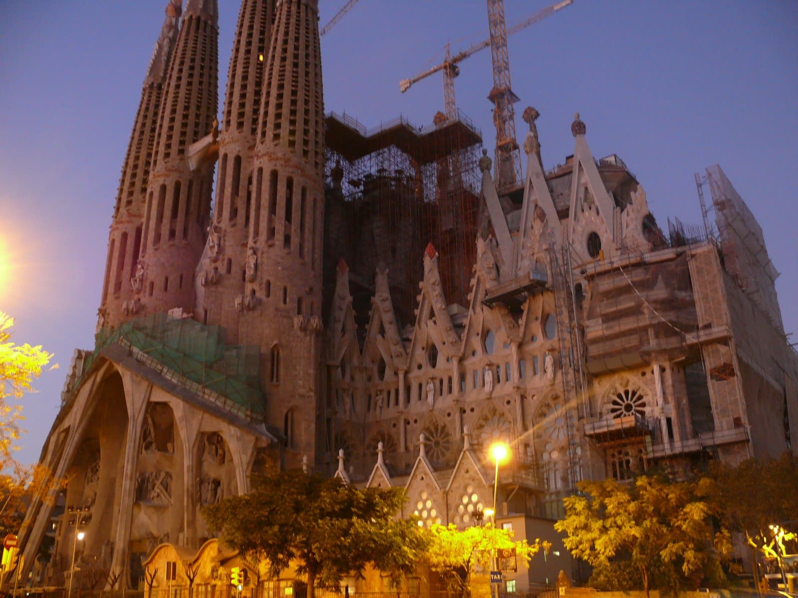 The illuminated Sagrada Família at dusk, its spires glowing against a twilight sky