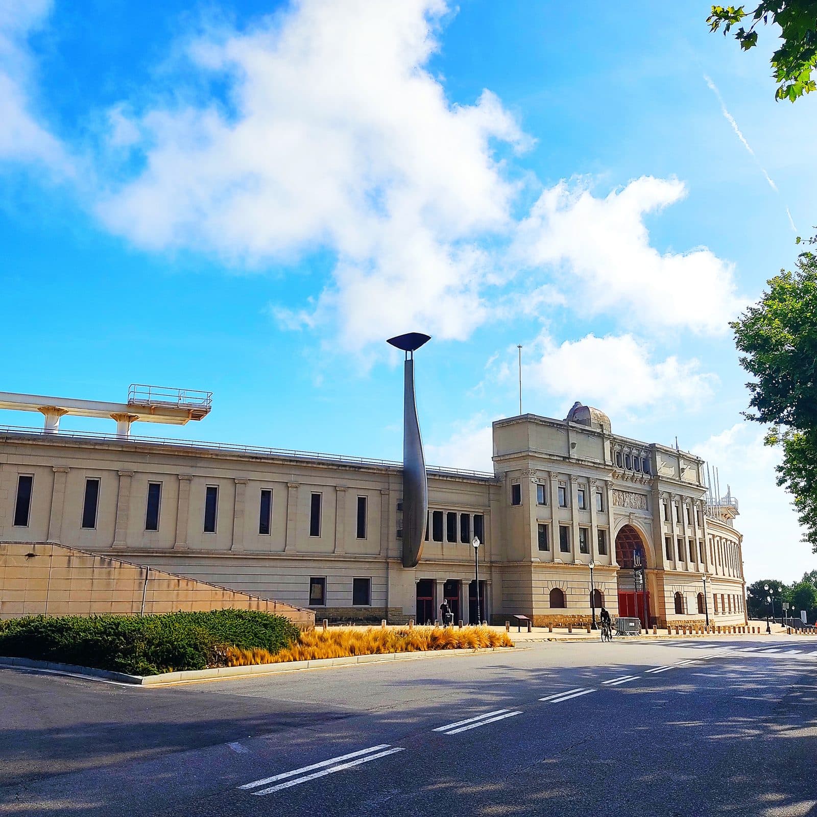 A monumental building on Montjuïc hill with a contemporary sculpture in front