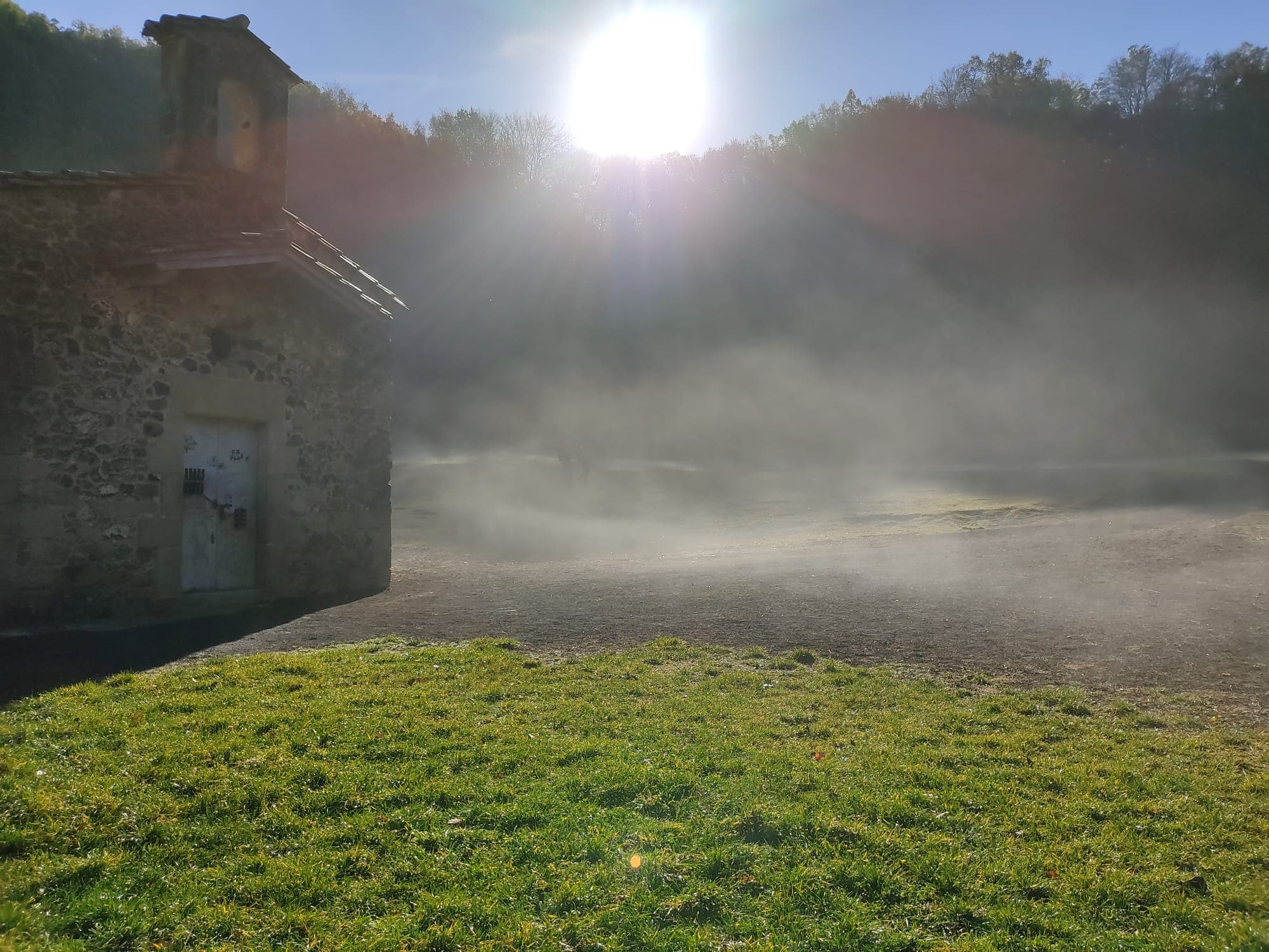 Morning mist and low sun over a meadow in the volcanic Garrotxa