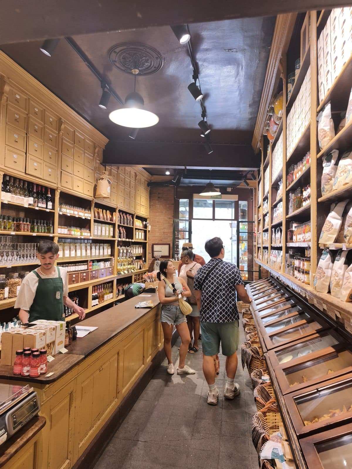The wood-panelled interior of a historic shop, staff serving behind the counter