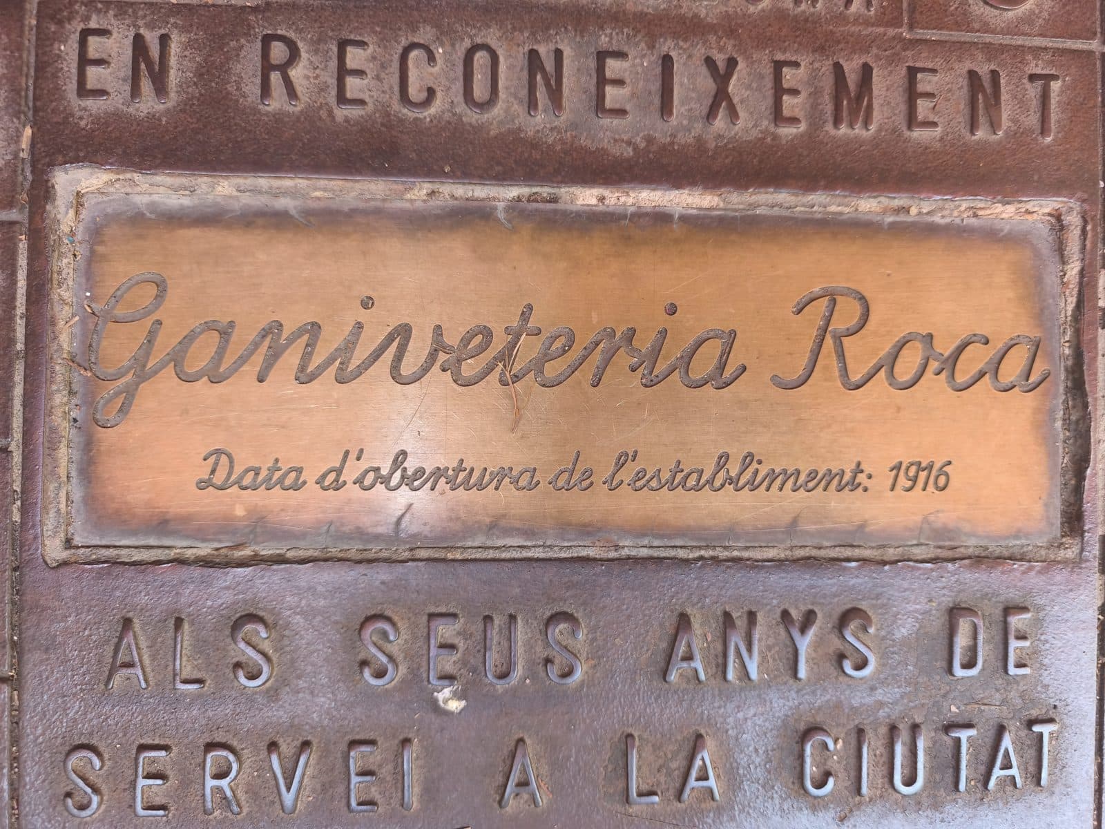 The engraved bronze plaque of Ganiveteria Roca, the historic cutlery shop, established 1916
