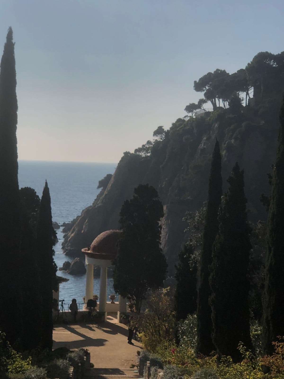 The domed Linnaeus Temple rotunda above the Mediterranean at Marimurtra, framed by cypresses
