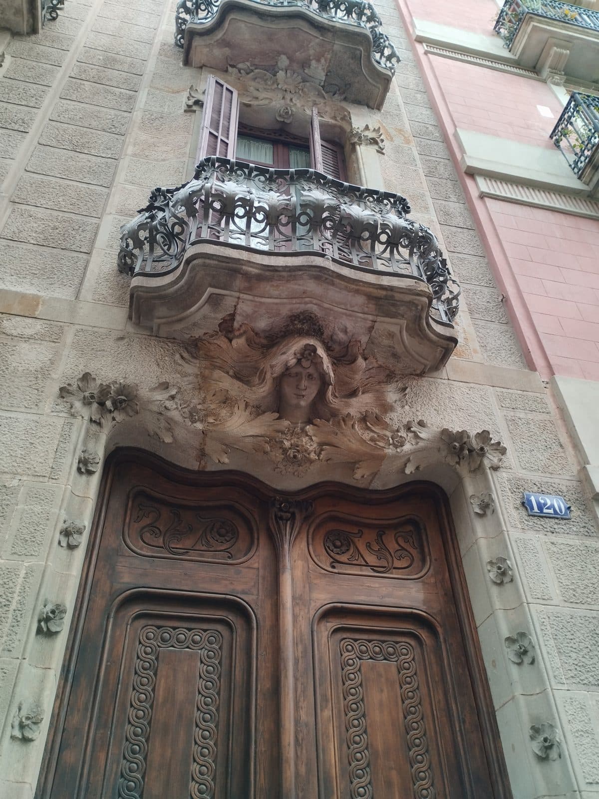 A carved Modernist stone doorway crowned by a sculpted female face