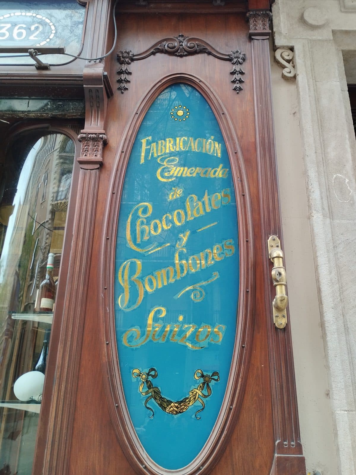 A historic chocolate shop’s oval glass sign in gilt lettering