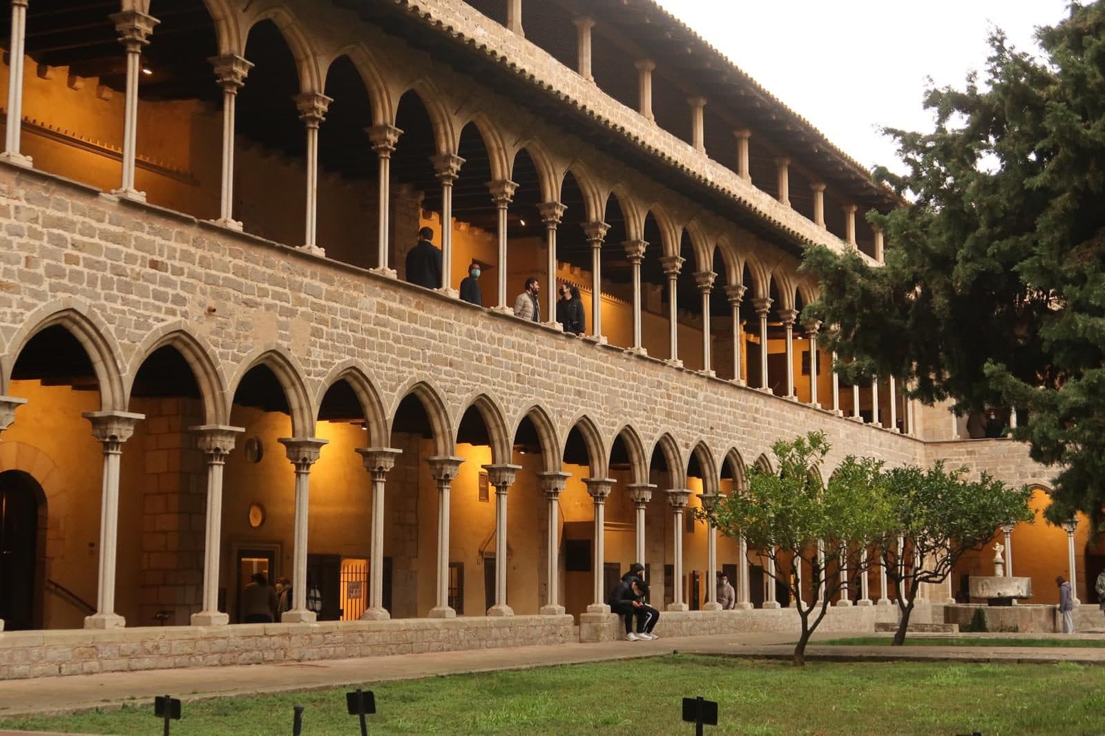 The slender Gothic arcades of the Pedralbes cloister seen across the garden