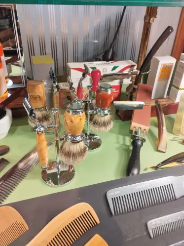Brochas de afeitar, navajas y peines dispuestos en el escaparate de una barbería