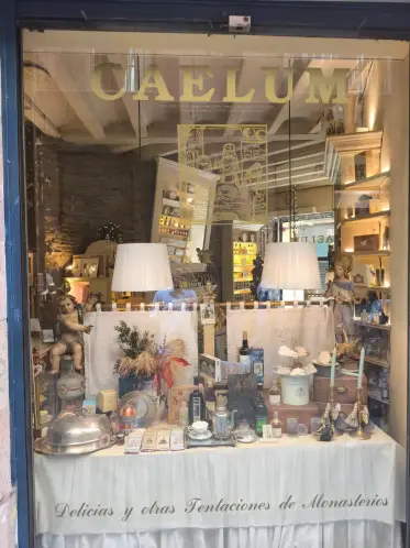 El escaparate iluminado de una tienda de delicatessen, con tarros y lámparas