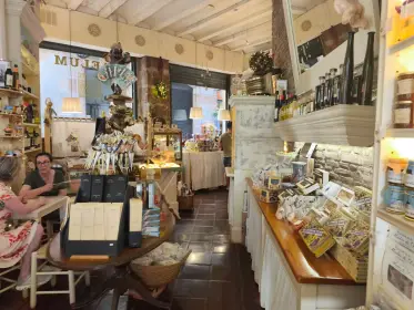 El interior de una vieja herboristería y colmado, con una clienta en el mostrador