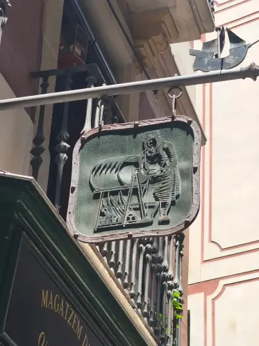 Un rótulo gremial de hierro forjado colgando sobre la calle
