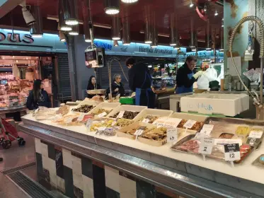 The fish counter laid out on ice, the fishmonger at work behind