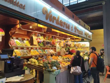 A greengrocer’s stall lit up behind its stacked crates