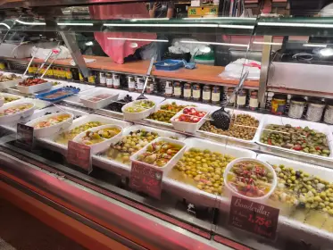 Trays of olives and marinated preparations in a glass counter