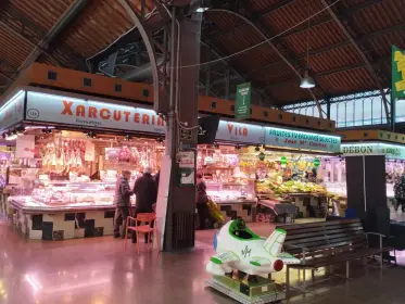 A xarcuteria stall under the coloured roof of Santa Caterina market