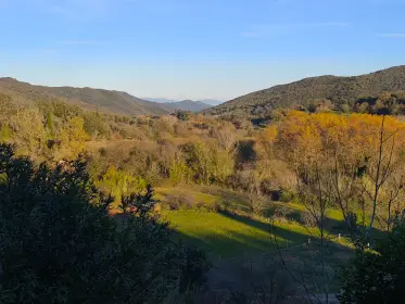 The valley in autumn colour, wooded hills folding into the distance
