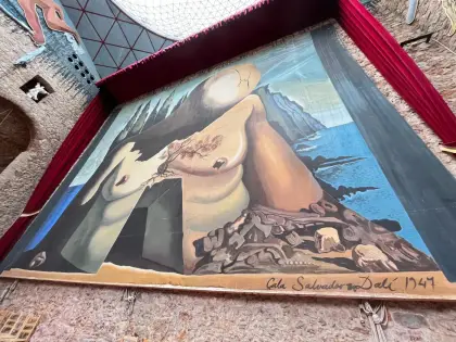 A Dalí canvas of a reclining figure in a bare landscape, signed and dated 1949
