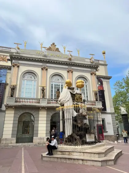 The Theatre-Museum facade in Figueres, golden figures ranged along the roofline