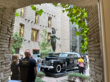 Visitors around the black Cadillac of the Rainy Taxi installation
