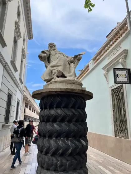 A sculpture mounted on a column of stacked tyres in the street outside