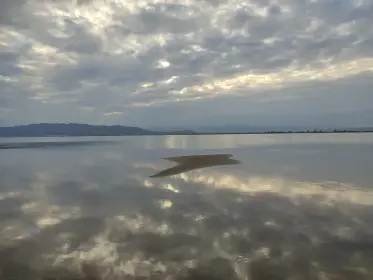 Núvols del capvespre reflectits en l’aigua llisa de la llacuna