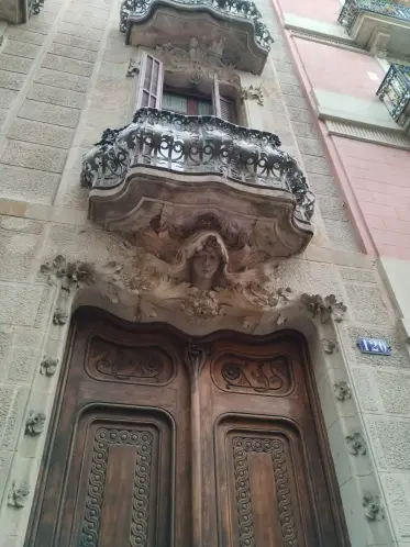 Una portada de piedra tallada con una cabeza esculpida sobre las puertas