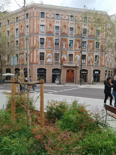 La fachada decorada vista desde una de las calles verdes del barrio