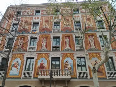 Figuras pintadas entre los balcones de una fachada decorada