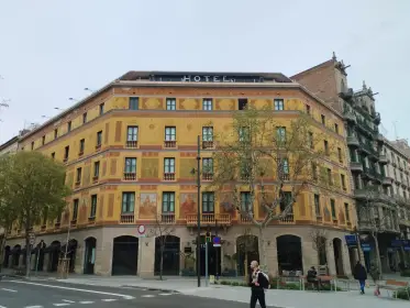 Un edificio en esquina cubierto de esgrafiados ocres