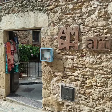 An art gallery doorway set into a rough stone wall