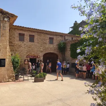 Diners gathered in a stone courtyard under flowering creeper