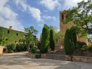 An ivy-clad house with cypresses standing at the garden wall