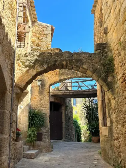 A stone archway spanning a lane between village houses