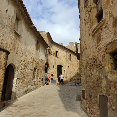 Visitors walking a broad street of golden stone houses