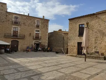 A quiet village square with a closed parasol and stone facades