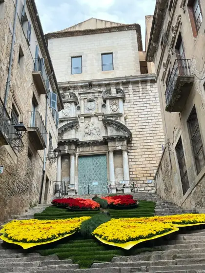 Alfombras de flores amarillas y rojas ante la fachada de una iglesia