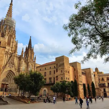 Barcelona Cathedral seen at an angle from the square, with the old town rooftops beyond