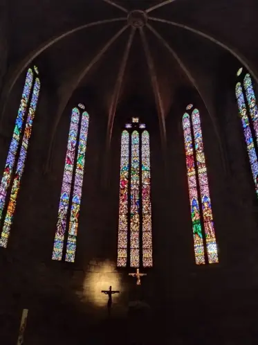 Tall stained-glass windows lighting a Gothic church interior