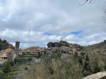 A hillside village with its church tower under a wide sky