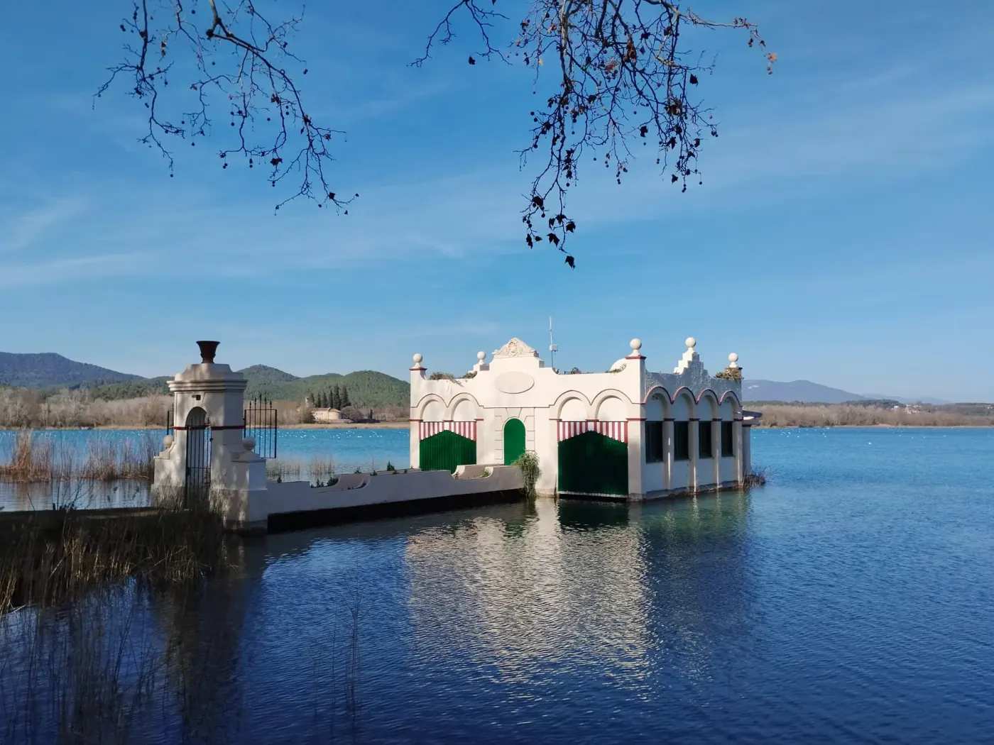 Un embarcadero de madera labrada sobre el agua quieta del lago