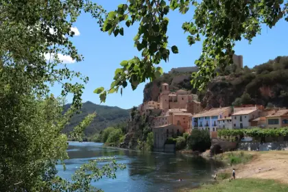 A riverside village climbing to the castle on the rock above