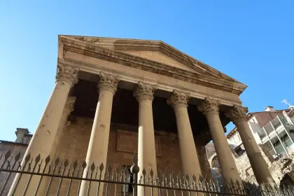The columns of the Roman temple rising behind its iron railing