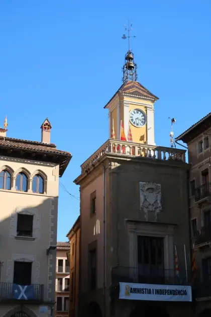 The clock tower of the town hall with flags on its balcony