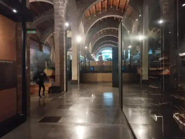 Una galeria llarga il·luminada rere el vidre al llarg de la nau