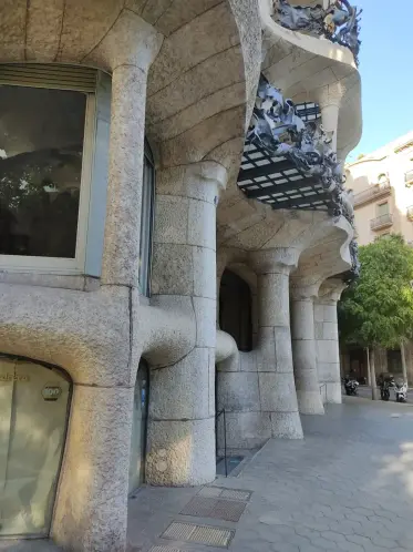 The stone piers and glazed gallery of La Pedrera at street level