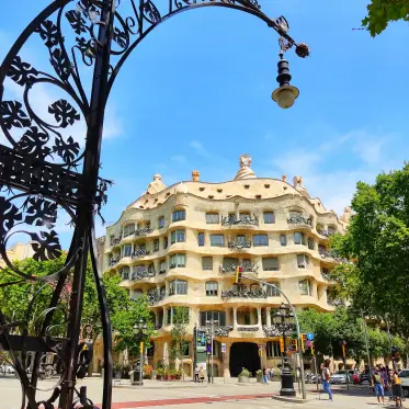 La Pedrera framed by the wrought iron of a modernist street lamp