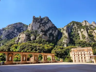 La plaça porticada del monestir amb el massís alçant-se al darrere