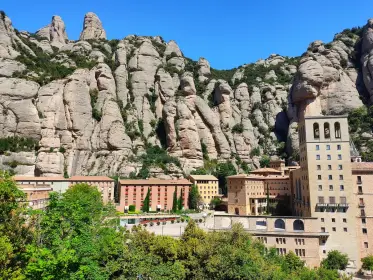 El conjunt del monestir a ple sol sota la paret de roca