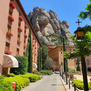 Edificis del monestir plens de flors contra la roca nua