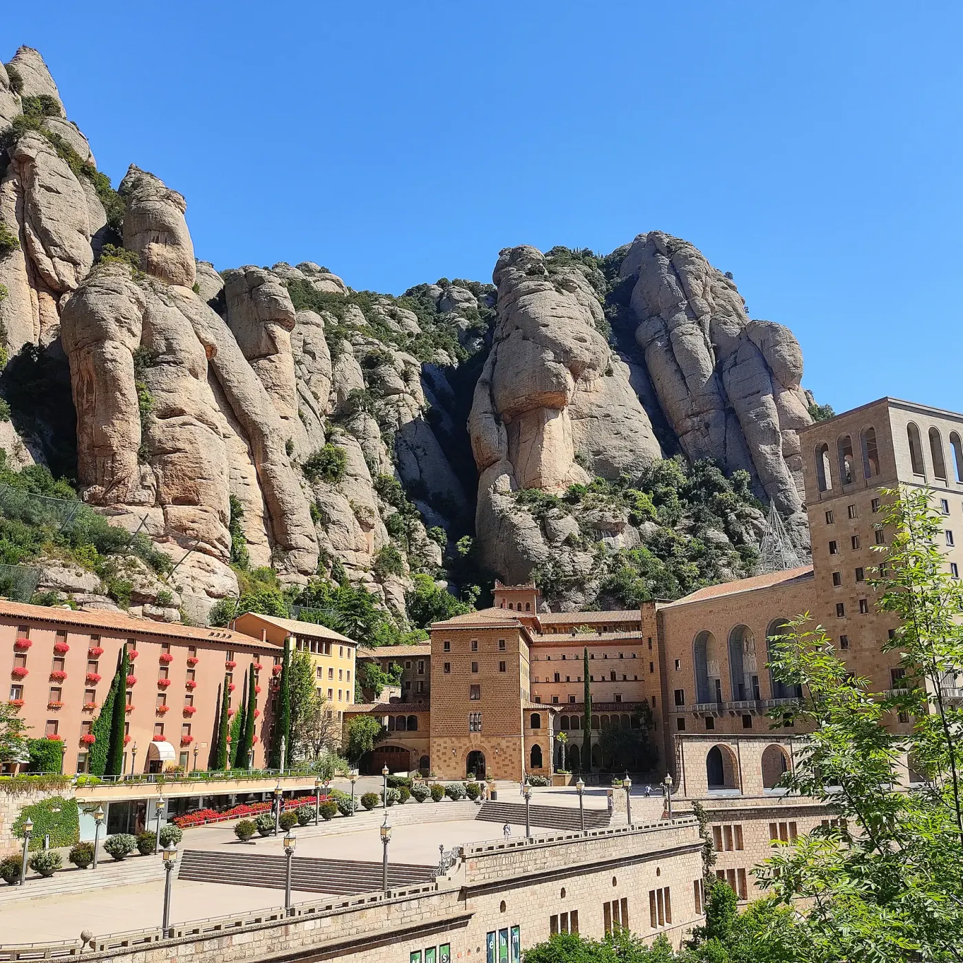 Los picos redondeados del macizo alzándose sobre los edificios del monasterio