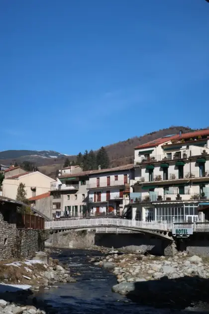 Balconied houses lining the river where it runs through the village