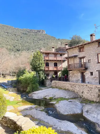 A riverside village gathered under a rock face